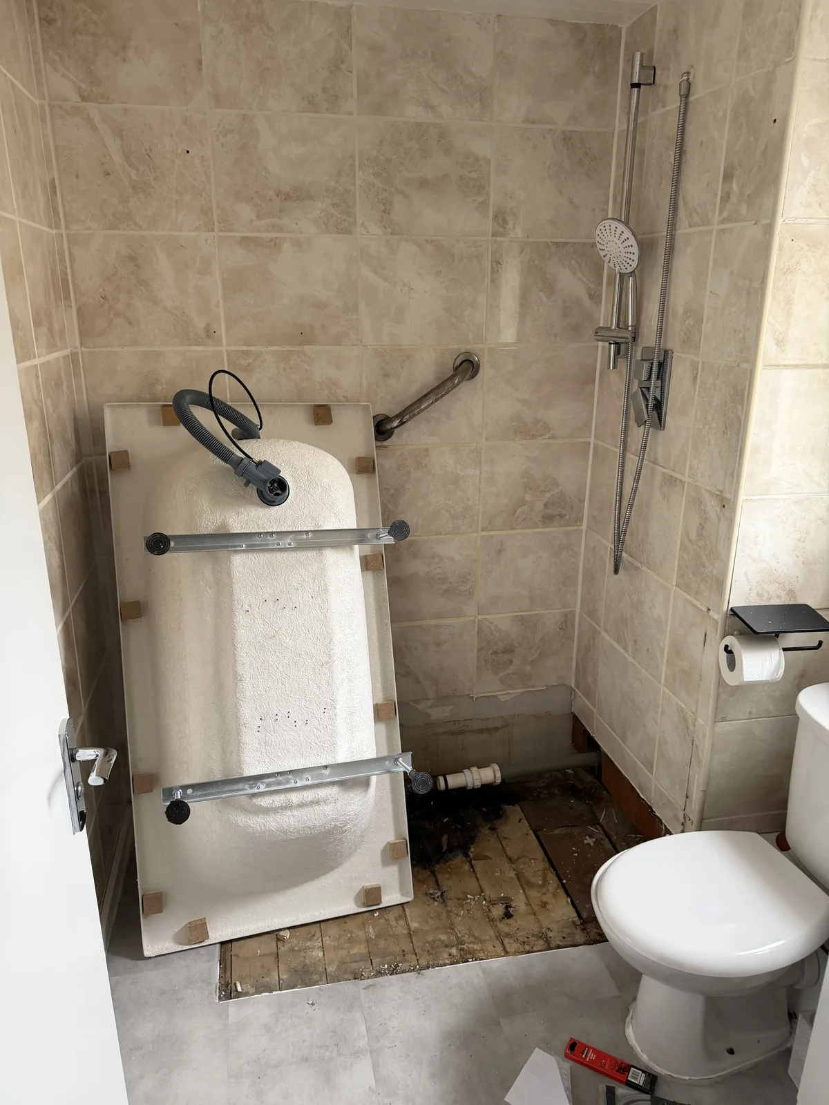 New bathtub being positioned in the former shower enclosure space in Basildon